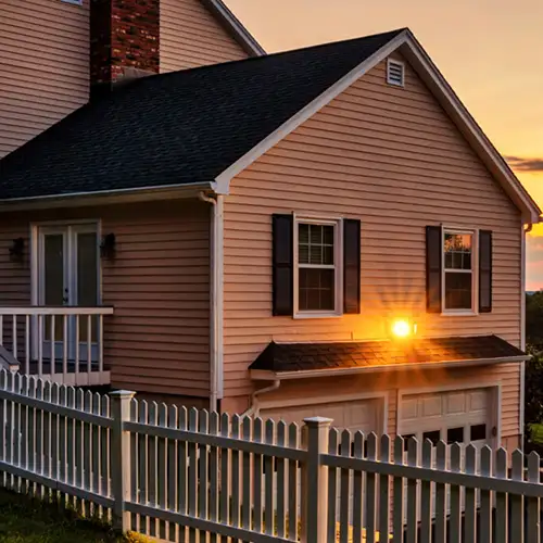 Suburban home with a white picket fence at sundown - Keep pests away from your home with Vermont Pest Control in Middletown Springs, VT