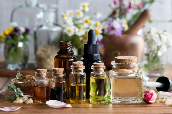 Bottles of essential oils and flowers on a table